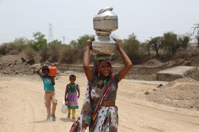 woman carrying water overhead