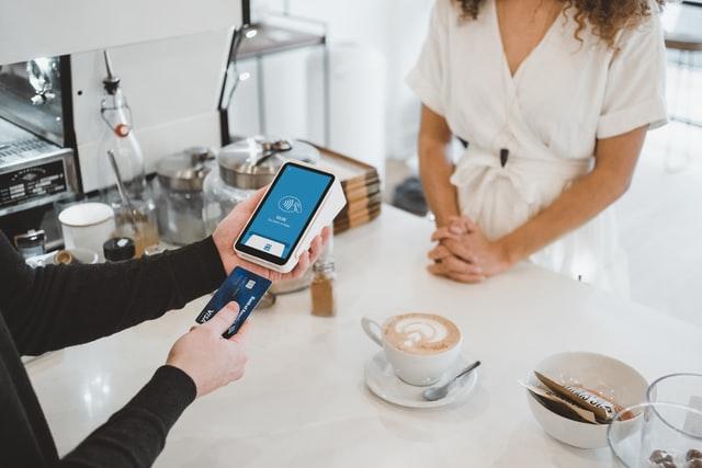 a woman paying coffee with credit card