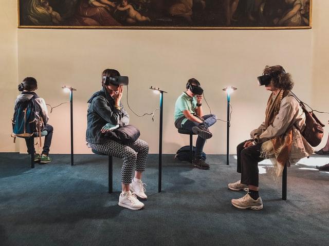 a group of youngster sitting together with vr headset