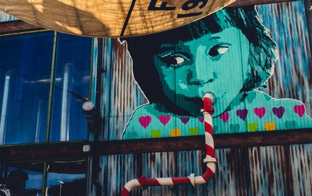 graffiti of a child sipping in pipe on a wall