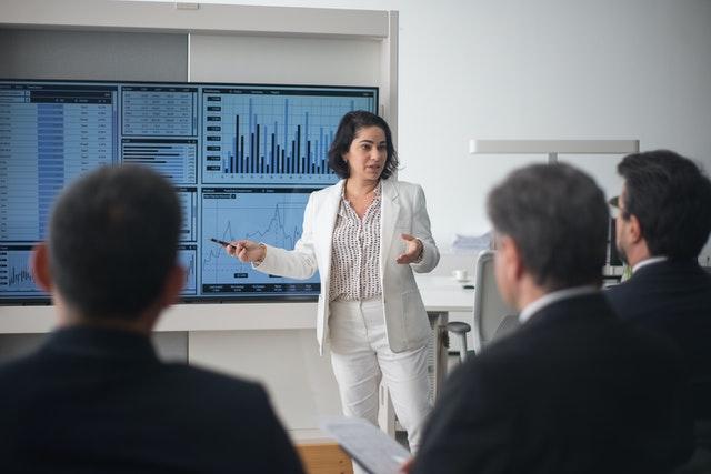 woman in white suit doing a present in a meeting