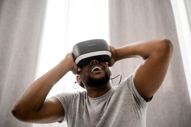 man with gray shirt wearing a white and black virtual reality mask