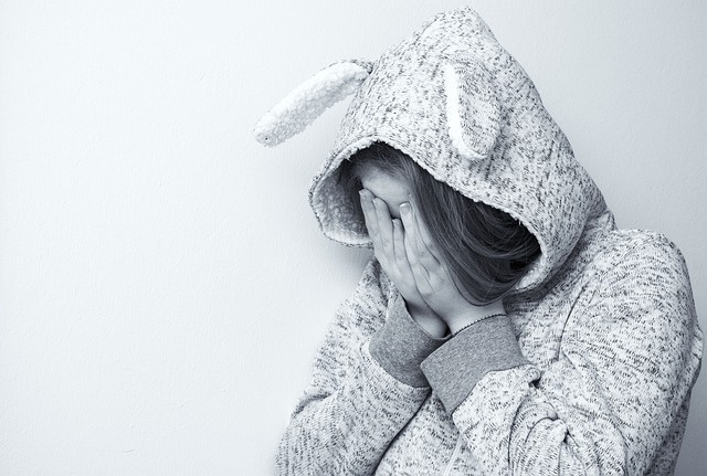 bullied woman hiding her face with her hands