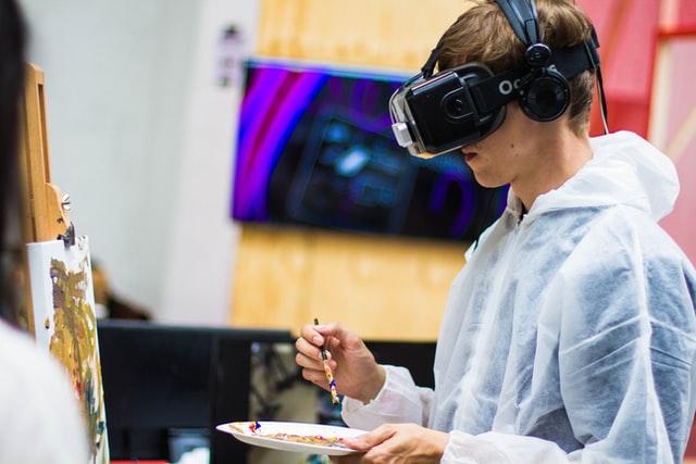 Boy wearing virtual reality google while making painting