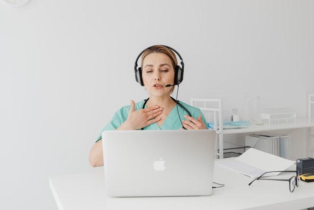 female doctor giving care to patient through video conference using laptop